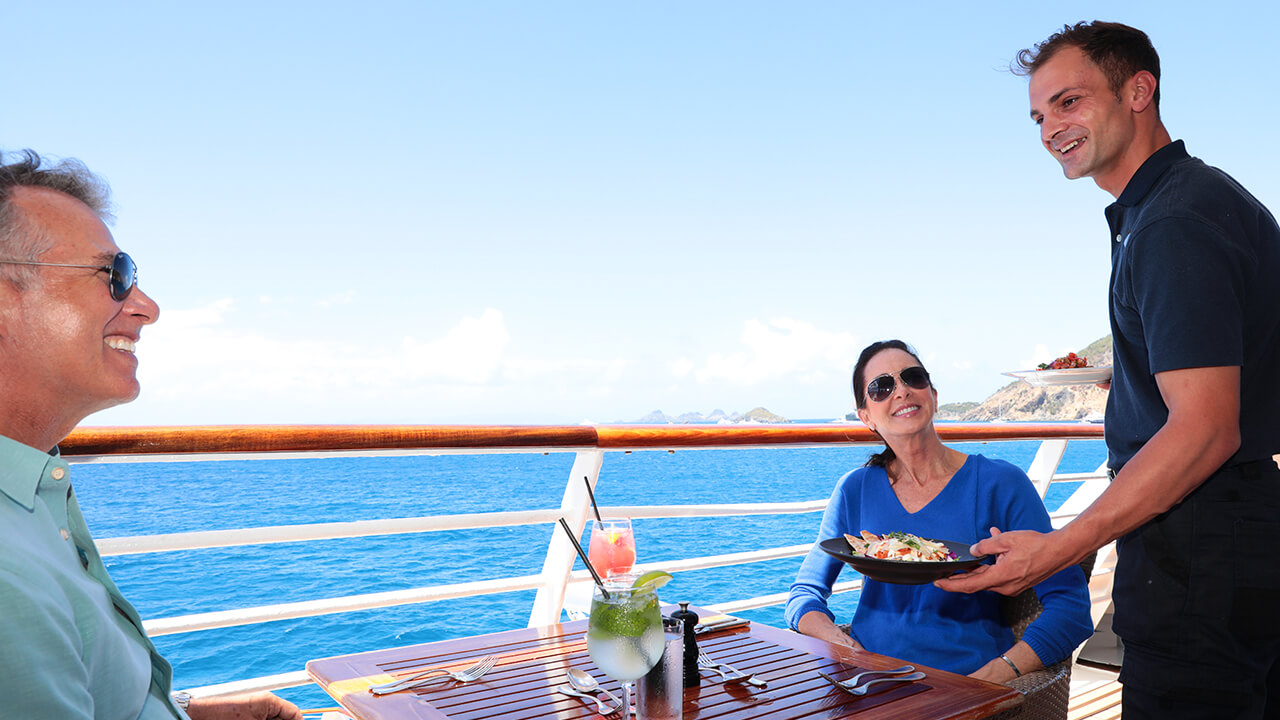 Couple being served lunch al fresco onboard SeaDream