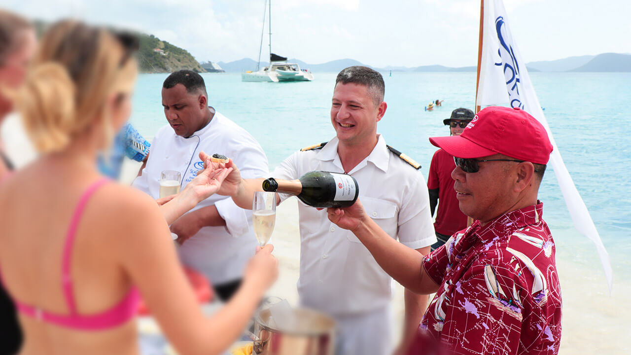 Serving champagne at the Champagne and Caviar Splash™ at Gordon's Beach, The Bahamas