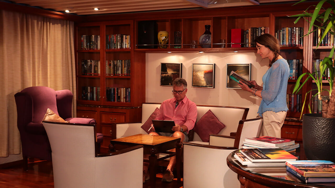 couple reading in the library onboard SeaDream